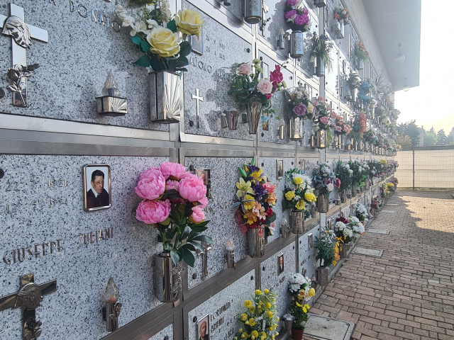 Parete con lapidi e fiori